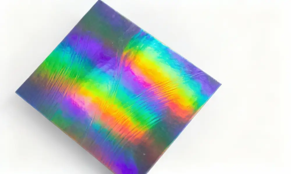 Holographic sticker light diffraction creating rainbow color spectrum Custom holographic sticker showing rainbow diffraction effect on metallized polyester film